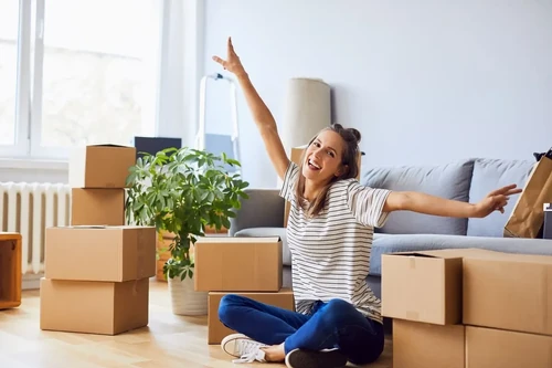 A happy woman smiles in her new apartment.