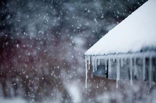 Ice freezes over a home’s gutters and roof in the middle of winter.