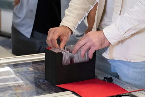 A man flips through a stack of trading cards in storage.
