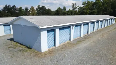 Wide view of multiple outdoor storage units with roll-up doors.