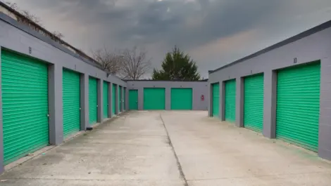 Several outdoor storage units with drive-up access and metal roll-up doors