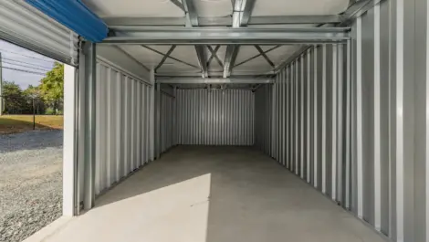 Inside view of a storage unit showing empty space and overhead lighting.