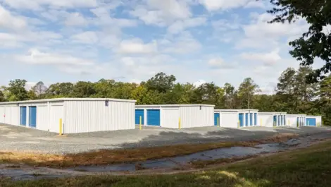 Outdoor storage units with metal doors and clear walkway.