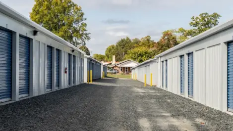 Exterior row of storage units with paved driveway in front.